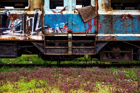Téléchargez les photos : Ancien train-bloc électrique rouillé à passagers multiples déclassé et abandonné sur une voie d'évitement ferroviaire sur un champ herbeux vert - en image libre de droit