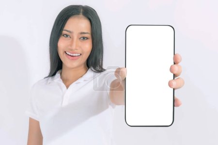 Téléchargez les photos : Belle femme brune asiatique mignonne fille en chemise blanche, Fille surprise excitée montrant grand téléphone intelligent avec écran blanc, écran blanc isolé sur fond blanc, Afficher l'image maquillée - en image libre de droit