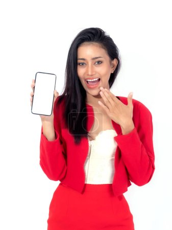 Téléchargez les photos : Belle femme brune asiatique mignonne fille en robe rouge, Fille surprise excitée montrant téléphone intelligent avec écran blanc, écran blanc isolé sur fond blanc, Image maquillée d'affichage - en image libre de droit