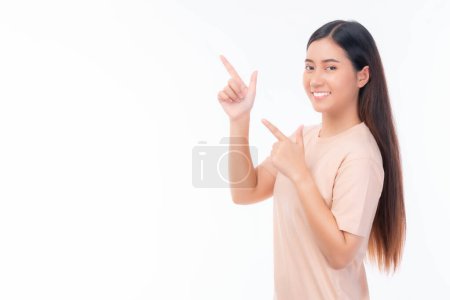 Téléchargez les photos : Belle beauté asiatique femme mignonne fille en robe rose souriant et pointant du doigt pour vider l'espace de copie pour présenter chaque produit, espace vide pour la publicité isolé sur fond blanc - en image libre de droit