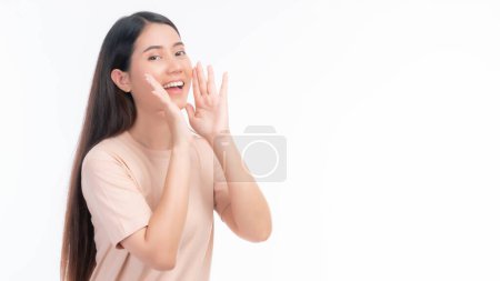 Foto de Hermosa mujer joven asiática de negocios grita anunciar la buena noticia o promoción, tomados de la mano cerca de su cara con la boca abierta Herald promoción de noticias sobre fondo blanco - Imagen libre de derechos
