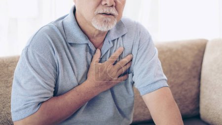 Téléchargez les photos : Homme âgé asiatique souffrant d'une mauvaise douleur dans sa poitrine crise cardiaque à la maison - maladie cardiaque senior - en image libre de droit