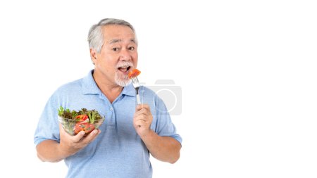 Téléchargez les photos : Mode de vie homme âgé se sentent heureux profiter de manger des aliments diététiques salade fraîche isolé sur fond blanc - en image libre de droit