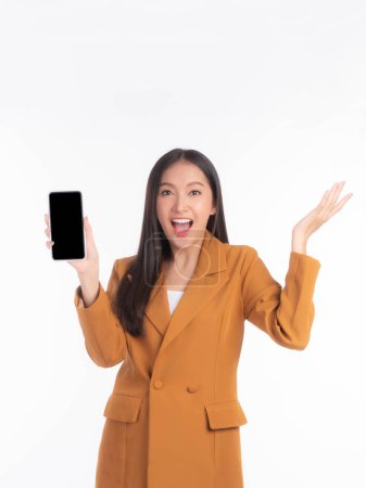 Téléchargez les photos : Portrait de belle jeune femme asiatique montrant le téléphone intelligent avec écran vide, écran noir vide espace de copie pour la bannière publicitaire isolé sur fond blanc, Mock Up Image - en image libre de droit