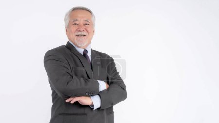 Téléchargez les photos : Portrait d'un homme d'affaires sénior avec costume, homme d'affaires sénior asiatique, vieil homme, se sentent heureux bonne santé debout bras croisés isolés sur fond blanc - style de vie concept masculin sénior - en image libre de droit