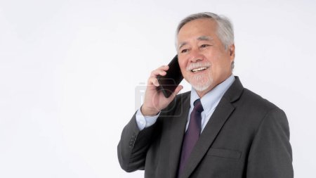 Foto de Asiático hombre de negocios senior, anciano usando un teléfono inteligente, sonriendo sentirse feliz aislado sobre fondo blanco, concepto para el éxito empresarial senior - Imagen libre de derechos