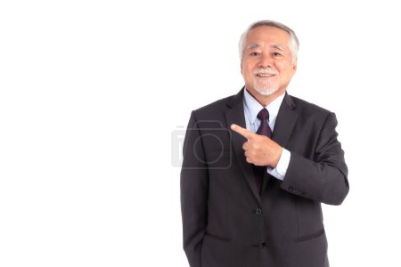 Téléchargez les photos : Asian senior businessman , old man with suit feel happy good health pointing finger to empty copy space for present product or blank space for advertising isolated on white background - en image libre de droit