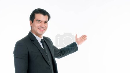 Téléchargez les photos : Portrait de travail asiatique costume homme d'affaires ware avec bonheur posant sa main vide avec espace de copie, espace vide pour la publicité ou un produit isolé sur fond blanc - concept d'entreprise - en image libre de droit