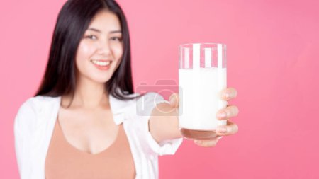 Photo for Beauty woman Asian cute girl feel happy drinking milk for good health in the morning on pink background - lifestyle beauty woman - Royalty Free Image