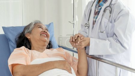 Téléchargez les photos : Doctors hold hands to encourage  Elderly senior woman patients in the hospital- senior female medical and healthcare concept - en image libre de droit