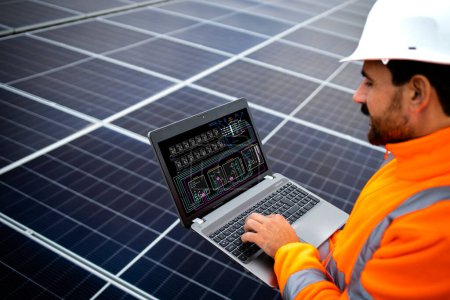 Installation von Sonnenkollektoren für nachhaltige Energie. Elektrotechniker hält Laptop mit Solarmodulen in der Hand und überprüft Produktivität.