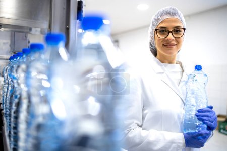 Portrait of experienced caucasian female employee working in bottling factory production line.