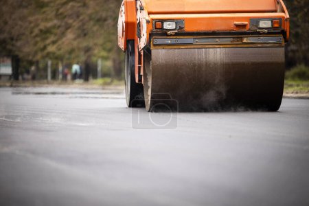 Photo for Asphalt paving machine working on new road construction. - Royalty Free Image