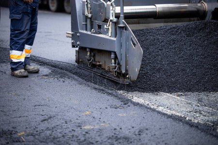 Photo for Asphalt paving machine adding new asphalt for road construction. - Royalty Free Image
