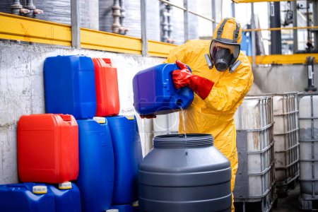 Téléchargez les photos : Travailleur professionnel de l'industrie chimique dans l'équipement de protection faisant des acides pour la galvanisation du zinc. - en image libre de droit