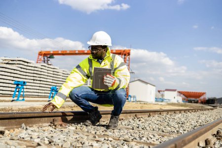 Photo for Railroad inspector supervisor doing quality control of train tracks at construction site. - Royalty Free Image