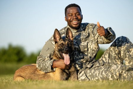 Retrato de soldado sonriente y perro militar disfrutando juntos.