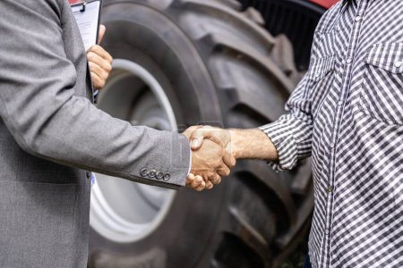 Téléchargez les photos : Investir dans les machines agricoles. poignée de main et achat d'un nouveau tracteur. - en image libre de droit