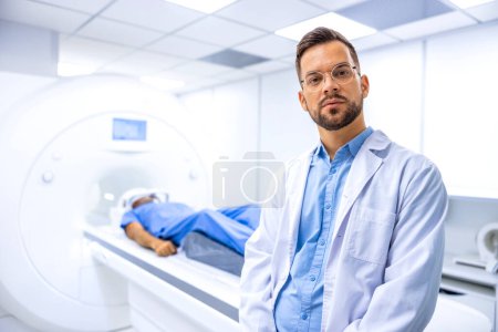 Retrato del radiólogo médico serio de pie dentro del centro de diagnóstico de RMN del hospital. Paciente preparándose para el examen de cuerpo completo.