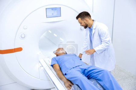Foto de Radiólogo experimentado alentando a pacientes mayores antes del procedimiento de resonancia magnética o tomografía computarizada en el hospital. - Imagen libre de derechos