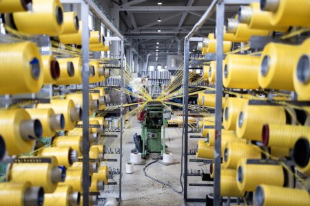 Photo for Industrial knitting machine with thread spool inside textile factory. - Royalty Free Image