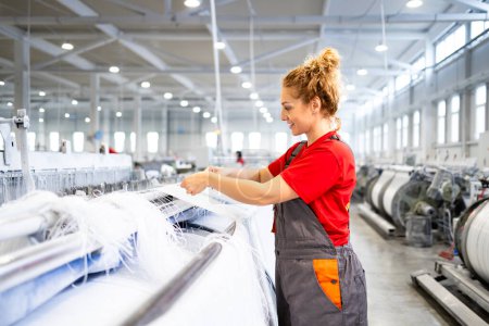 Trabajadora trabajadora que trabaja en máquinas de coser industriales produciendo alfombras.