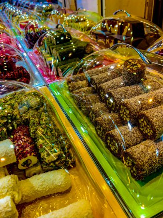 Foto de Traditional oriental sweets in store on counter. These are Turkish delight, sherbet, nougat, halva, churchkhela. Prepared from sugar syrup or granulated sugar, nut and all kinds of fruits and berries - Imagen libre de derechos