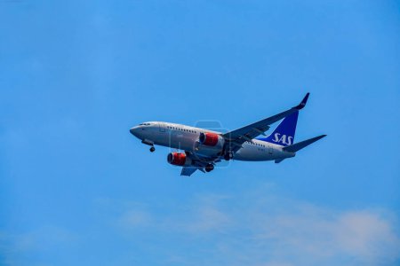 Photo for Santorini, Greece - July 09, 2022: SAS plane is flying in the sky. SAS bring in new and fuel-efficient aircraft and has one of Europe's most modern fleets. - Royalty Free Image