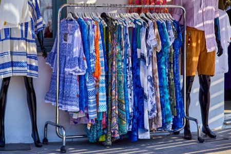 Photo for Clothes rack with boho hippie style floral pattern women's clothing at outdoor fashion market - Royalty Free Image