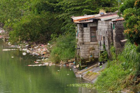 Téléchargez les photos : Pauvres gens vivant dans la pauvreté le long des canaux de Manille Philippines avec un espace de copie - en image libre de droit