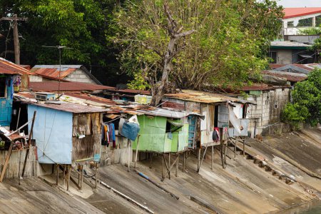 Poor people living in poverty along the canals of Manila Philippines with copy space
