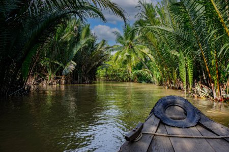 Téléchargez les photos : A small boat traveling along a canal in the Mekong Delta region southern Vietnam - en image libre de droit