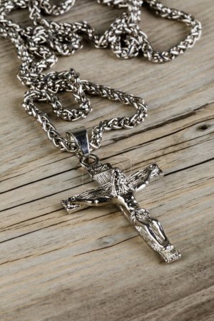 Photo for Close up of a silver Crucific necklace isolated on a wooden background with copy space - Royalty Free Image