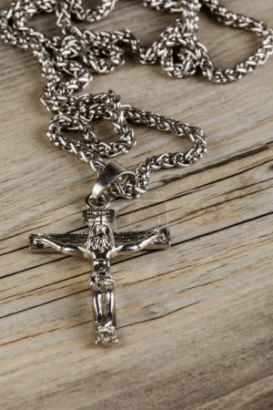 Photo for Close up of a silver Crucific necklace isolated on a wooden background with copy space - Royalty Free Image