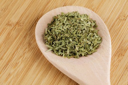 Photo for Dried Tarragon Leaves isolated on a wooden spoon and wooden cutting board with copy space - Royalty Free Image