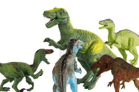 Foto de Un grupo de pequeños dinosaurios Tyrannosaurus Rex de juguete atacando a un gran Tiranosaurio adulto aislado sobre un fondo blanco - Imagen libre de derechos