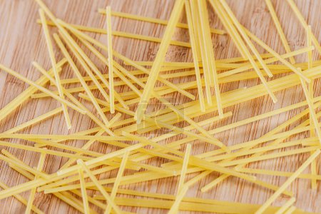 Téléchargez les photos : Spaghetti sec isolé sur une planche à découper en bois - en image libre de droit