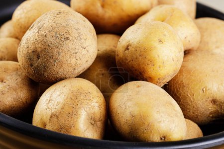 Foto de Cerrar un tazón lleno de deliciosas patatas crudas con espacio para copiar - Imagen libre de derechos