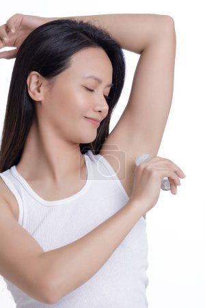 Foto de Hermosa mujer asiática aplicando desodorante para una buena higiene personal aislada sobre un fondo blanco con espacio para copiar - Imagen libre de derechos