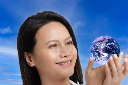 Téléchargez les photos : Femme asiatique célébrant le Jour de la Terre isolé sur un fond bleu ciel avec espace de copie - en image libre de droit
