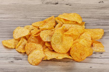 Photo for Delicious Barbeque Flavored Potato Chips isolated on a wooden background with copy space - Royalty Free Image