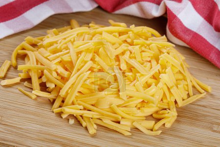 Photo for Close up of delicious Grated Cheddar Cheese on a wooden background with copy space - Royalty Free Image