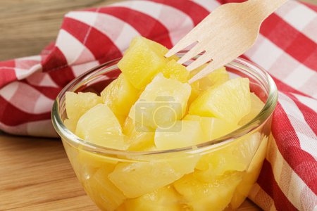 Photo for A close up of delicious Pineapple Chunks is juicy Syrup on a wooden background with copy space - Royalty Free Image