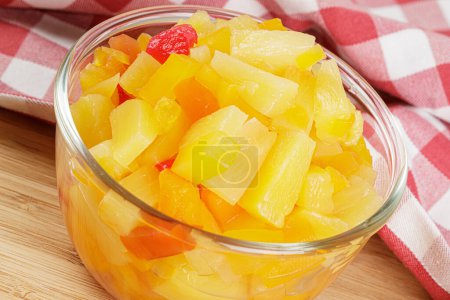 Photo for A delicious glass bowl of Fruit Cocktail mix isolated on a wooden background with copy space - Royalty Free Image