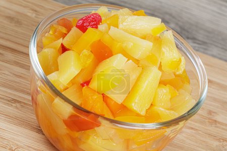 Photo for A delicious glass bowl of Fruit Cocktail mix isolated on a wooden background with copy space - Royalty Free Image