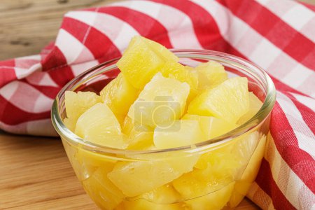 Photo for A close up of delicious Pineapple Chunks in juicy Syrup on a wooden background with copy space - Royalty Free Image