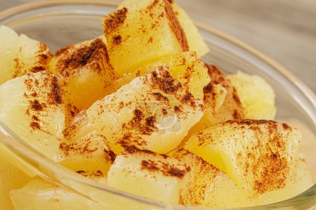 Photo for A close up of delicious Pineapple Chunks and Cinnamon Power in juicy Syrup on a wooden background with copy space - Royalty Free Image
