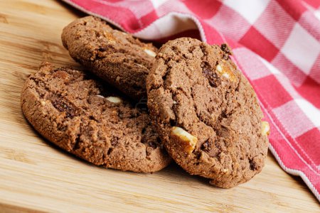 Téléchargez les photos : Gros plan de délicieux biscuits aux pépites de chocolat tentants sur un fond en bois avec espace de copie - en image libre de droit
