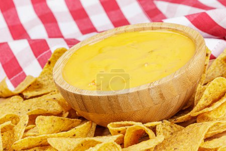 Foto de Un gran tazón de madera de deliciosa salsa de queso y tortilla de maíz tostado o chips de Nacho sobre un fondo de madera con espacio para copiar - Imagen libre de derechos