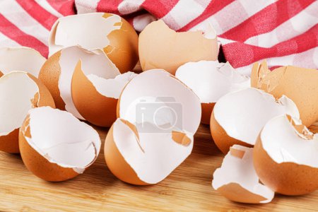 Foto de Primer plano de las cáscaras de huevos marrones orgánicos rotos sobre fondo de madera con espacio de copia - Imagen libre de derechos